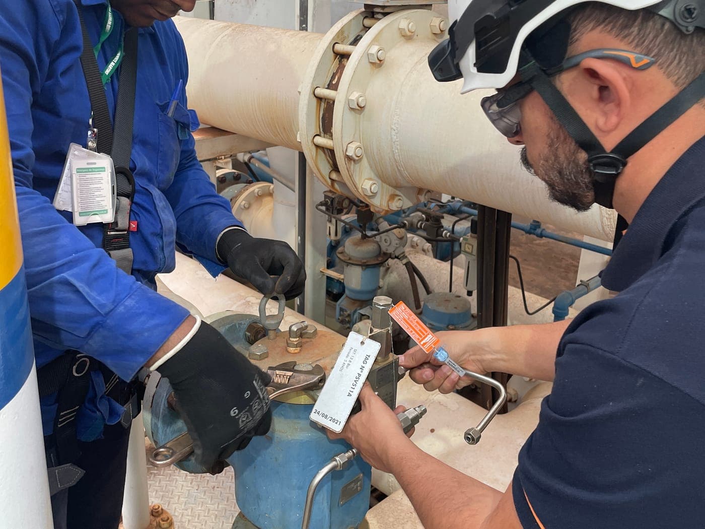 Técnicos fazendo ensaio de válvula de segurança identificada por plaqueta de TAG